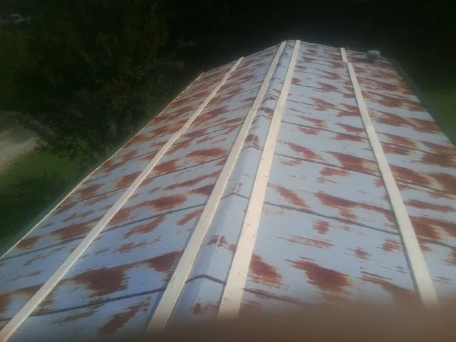Rusted metal roof panels with new wood purlins before replacement — Storm Damage Roof Repair in Cresco by Roofing Brothers