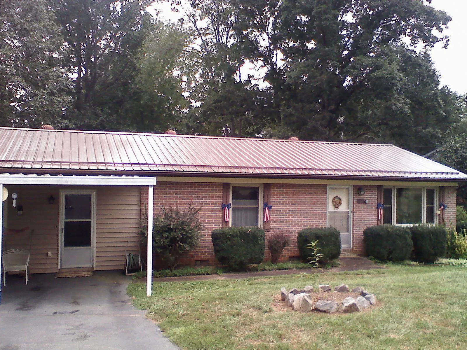 Bronze metal roof and carport on a brick ranch home — Roof Repair work by our crew in Cresco